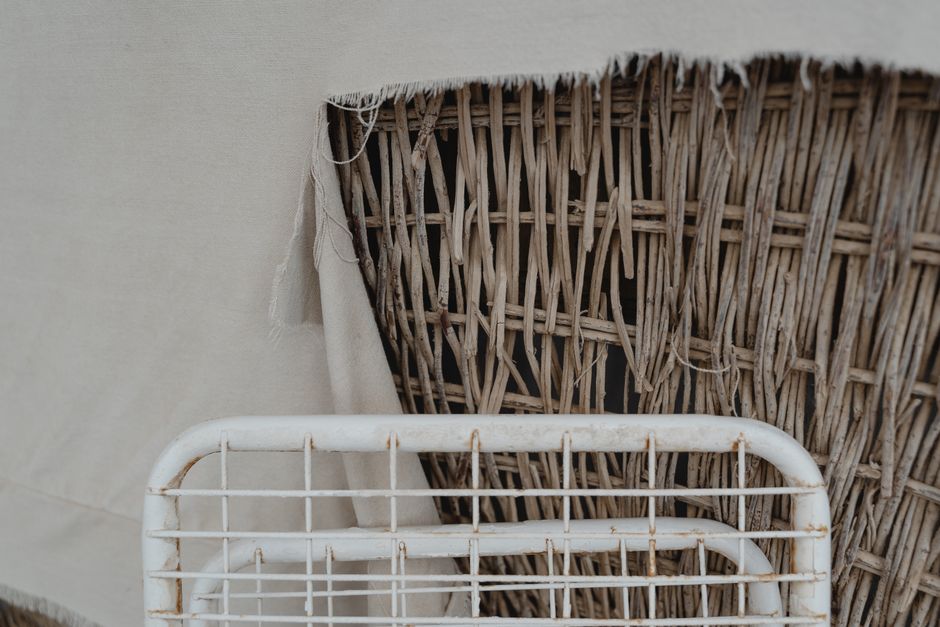 A detailed view of woven rattan against torn fabric with aged metal grid.